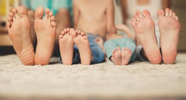 birlikte yatağa odak ayaklarının üzerinde yatan aile.