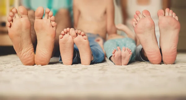 Familia acostada en la cama juntos-concéntrate en tus pies . —  Fotos de Stock