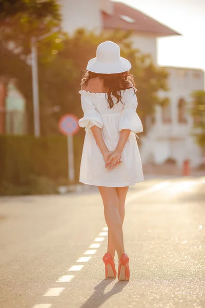 Femme seule dans un chapeau sur une route vide — Photo