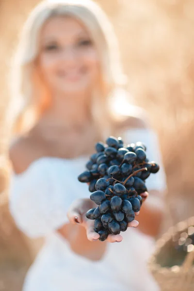 Porträt einer Frau mit Weintraube in der Hand — Stockfoto