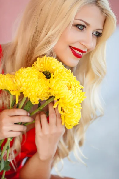 Schönes Mädchen mit einem Strauß gelber Blumen. — Stockfoto