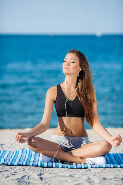 The woman meditates on a beach near the sea — Stock Photo, Image