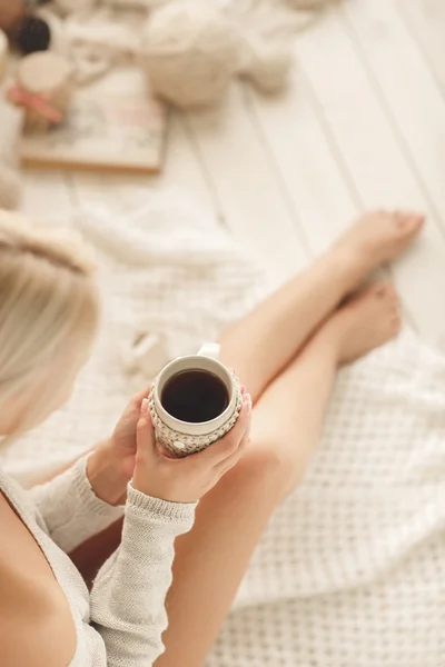 Junge Frau trinkt Kaffee zu Hause in seinem Zimmer. — Stockfoto