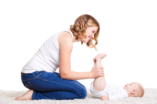 Máma dělá cvičení s dítětem na podlaze. — Stock fotografie