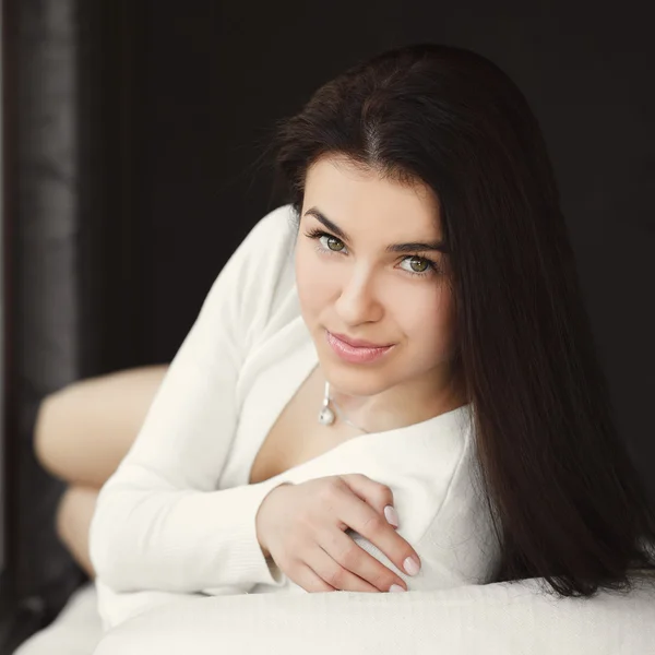 Retrato de una joven acostada en la cama junto a la ventana . — Foto de Stock