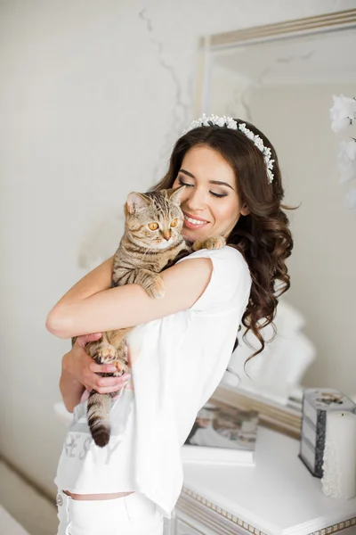 De vrouw in de slaapkamer met de kat in haar armen. — Stockfoto