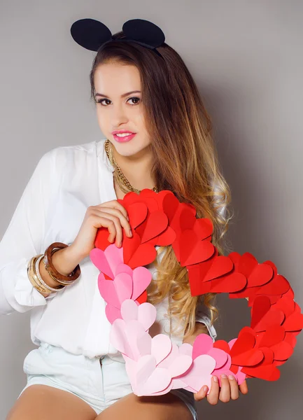 Schöne Frau mit dem Symbol Valentinstag in seinen Händen. — Stockfoto