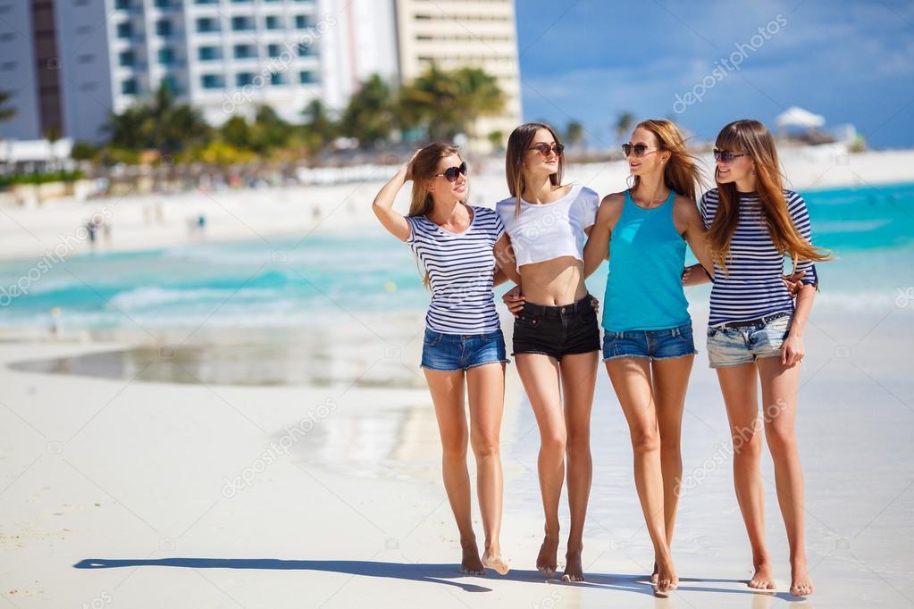 Beautiful girls are photographed on a tropical resort on the background of the beach and ocean.