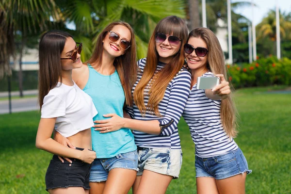 Piękne dziewczyny są fotografowane na ośrodek na tle zieleni. — Zdjęcie stockowe