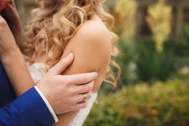 Damat gelini yeşil bir parkta yaz aylarında kisses.