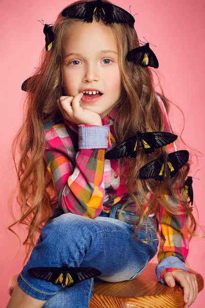 Studio portret van een klein meisje met tropische vlinders. — Stockfoto