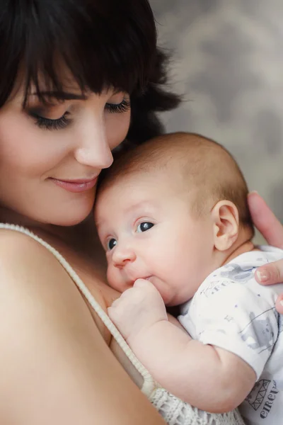 Madre joven con su bebé en sus brazos . — Foto de Stock