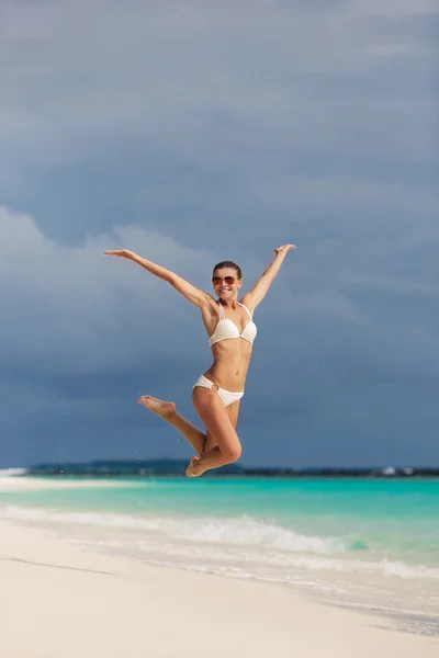 Kobieta, skoki na tle na plażę i morze. — Zdjęcie stockowe