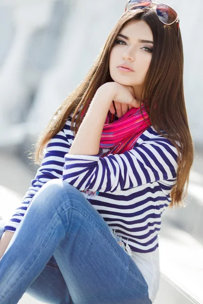 Portrait of a beautiful young woman sitting on the steps. — Stock Photo, Image