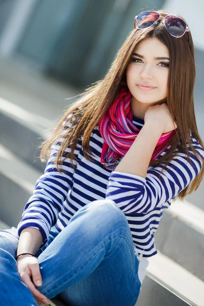 Porträt einer schönen jungen Frau, die auf den Stufen sitzt. — Stockfoto