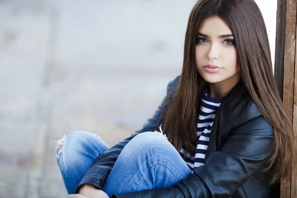 Portrait of a beautiful young woman sitting on the sidewalk. — Stock Photo, Image