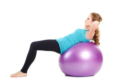 Kız-fitness eğitmeni, çalışmaları büyük bir top ile gösterir.