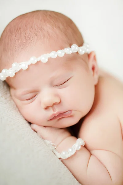 Photo of a newborn baby curled up sleeping on a blanket — Stock Photo, Image