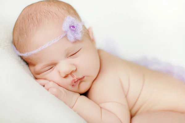 Photo of a newborn baby curled up sleeping on a blanket — Stock Photo, Image