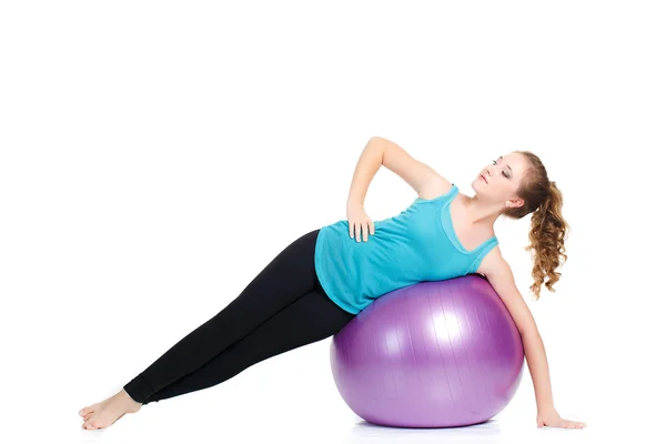 Chica instructor de fitness, muestra ejercicios con una pelota grande . — Foto de Stock