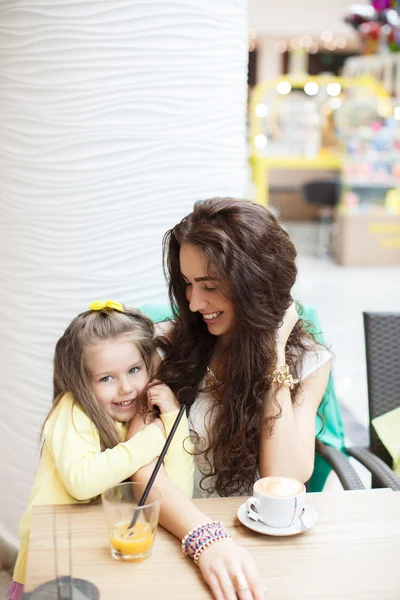 Mamá y su hija beben café y jugo en un supermercado de café . — Foto de Stock