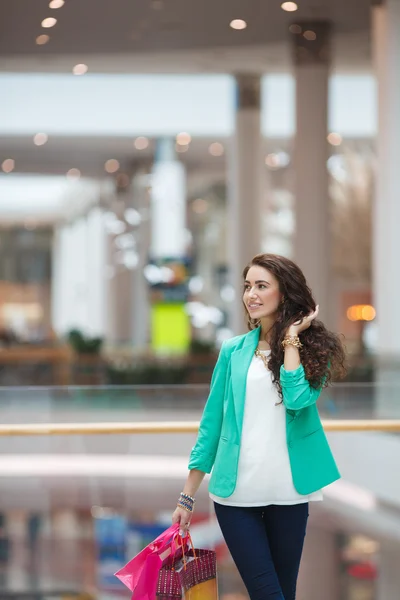 Young woman with shopping bags on the background of shop windows — Stock Photo, Image