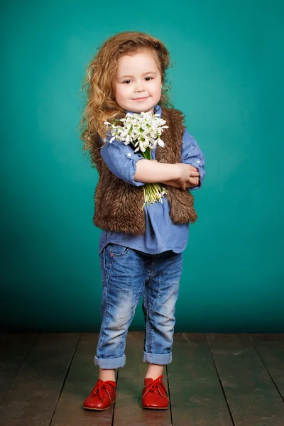 Krásná holčička s velkou kyticí sněženky. — Stock fotografie