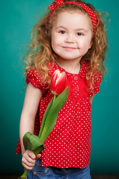 Schönes kleines Mädchen mit einem großen Strauß Tulpen. — Stockfoto