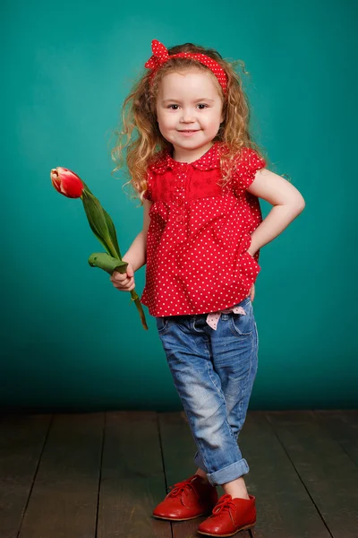 Schönes kleines Mädchen mit einem großen Strauß Tulpen. — Stockfoto