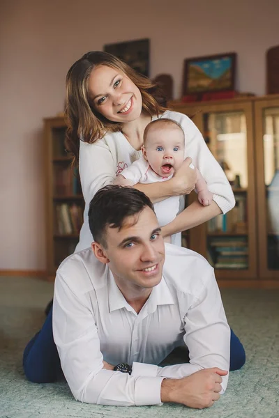 Happy young family with a small child in her arms. — Stock Photo, Image