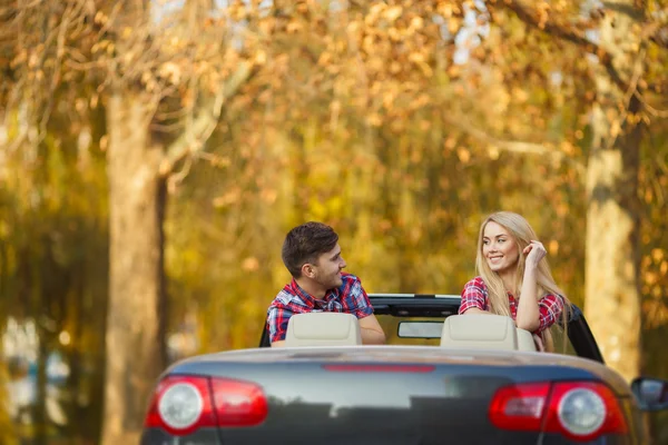 Couple amoureux dans une décapotable noire dans le parc d'automne . — Photo