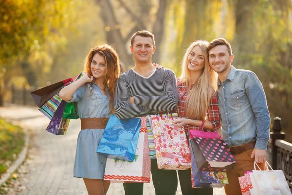 Två unga par i parken med påsar på väg till gallerian. — Stockfoto