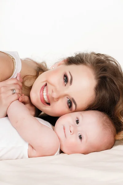 Retrato de madre feliz con bebé sobre un fondo blanco . — Foto de Stock