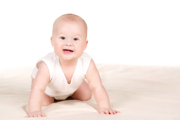 Charming babe is sitting on the bed, on a white background. — Stock Photo, Image