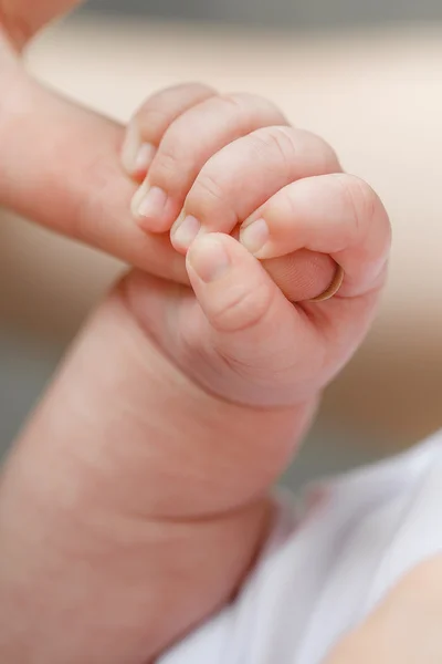 Primer plano de la mano del bebé sosteniendo el dedo de la madre — Foto de Stock