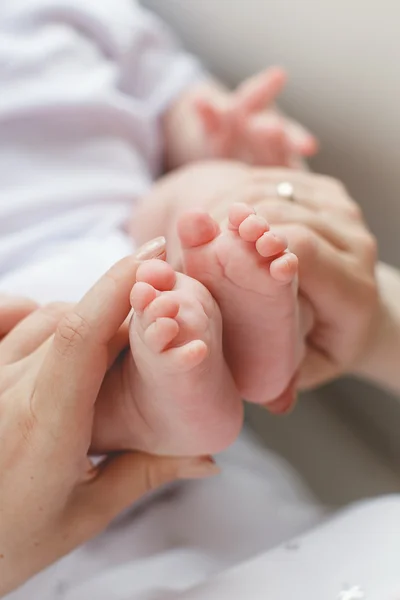 Pied de bébé entre les mains de la mère . — Photo