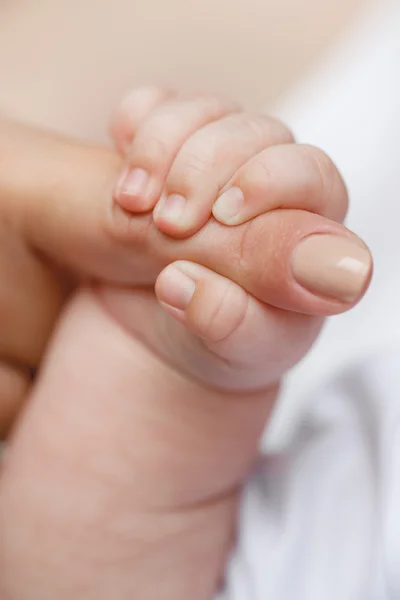 Annenin parmağını tutarken bebeğin elini yakın plan çek. — Stok fotoğraf