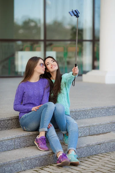 Dos mujeres jóvenes y atractivas son fotografiadas con un smartphone en las calles . — Foto de Stock