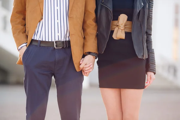 Young beautiful stylish couple in love holding hands on the street — Stock Photo, Image