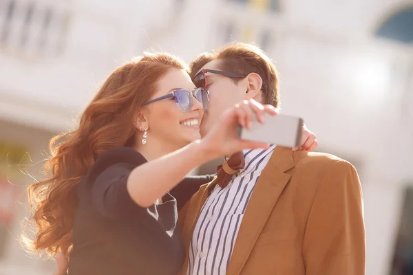 Das Paar wird in der Stadt mit dem Smartphone fotografiert — Stockfoto