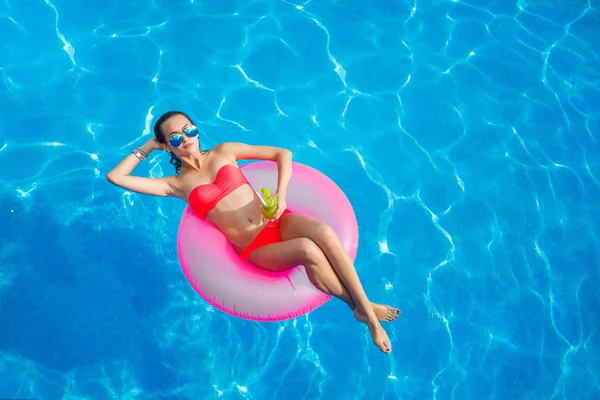 Bella ragazza in piscina sulla boa di salvataggio gonfiabile — Foto Stock