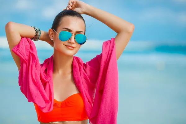 Atraktivní mladá žena s červenými pareo na pláž — Stock fotografie