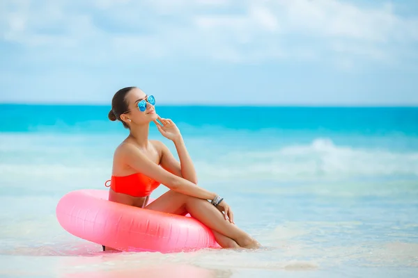 Bella donna con una boa di vita gonfiabile su una spiaggia tropicale — Foto Stock