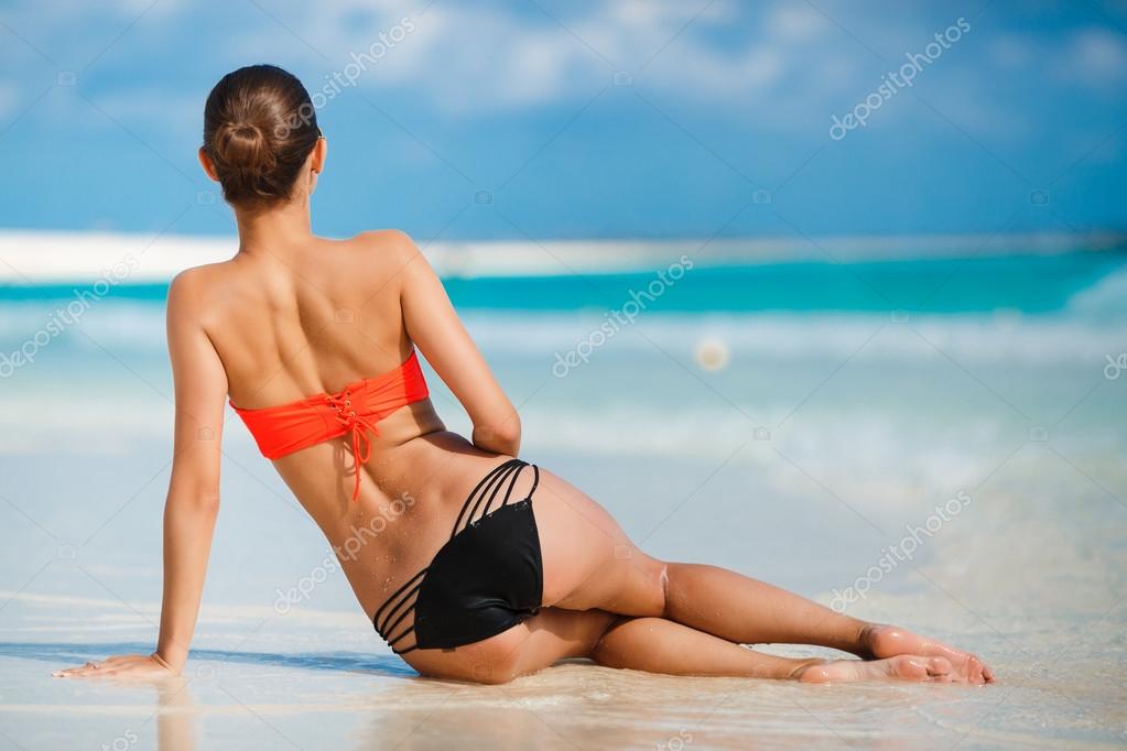 Brunette teen in bikini and beachwear enjoys the summer sun. Stock
