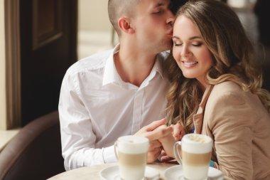 Happy couple drinking coffee in an urban café.