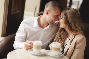 Happy couple drinking coffee in an urban café.