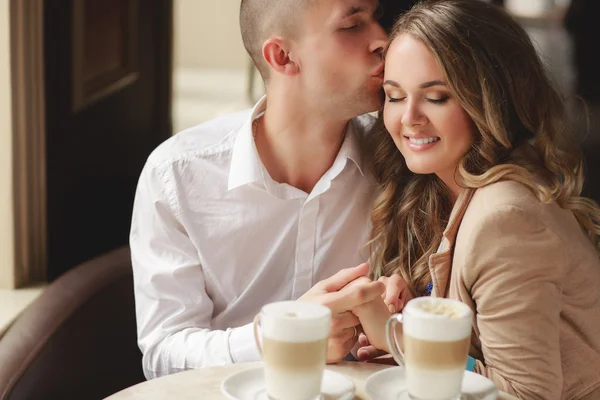 Happy couple drinking coffee in an urban café. — Zdjęcie stockowe