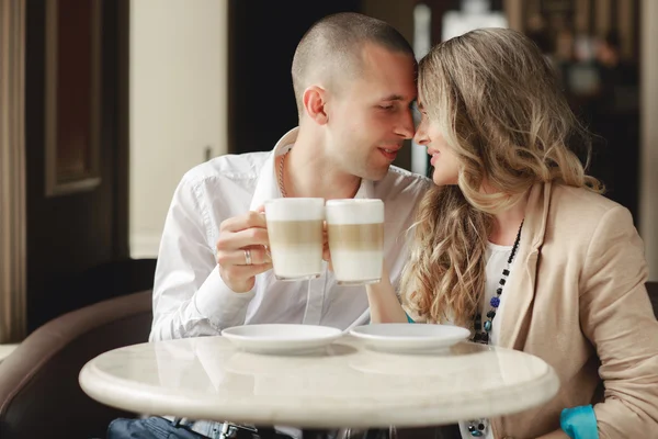 Happy couple drinking coffee in an urban café. — Zdjęcie stockowe