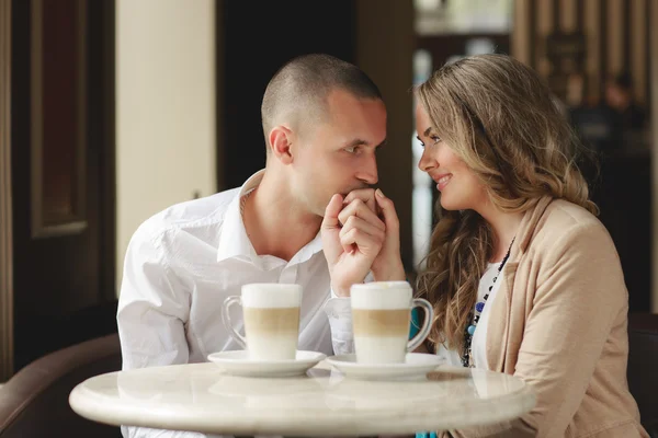 Happy couple drinking coffee in an urban café. — Stockfoto