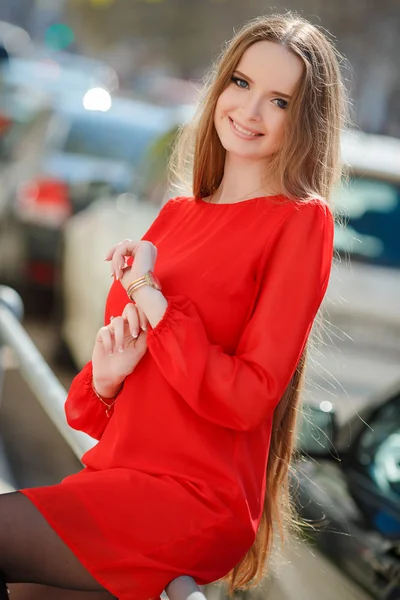 Joven hermosa mujer de pie en la calle de la ciudad con coche nuevo en el fondo —  Fotos de Stock